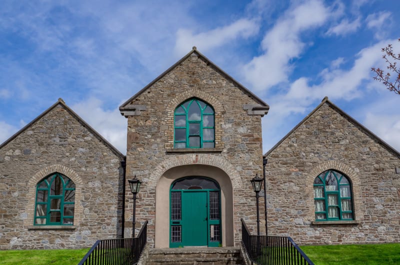 Stone Building With Green Door And Arched Windows mrtsnt
