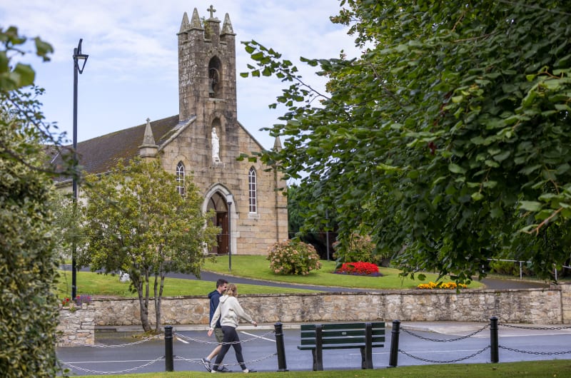 Stone Church Bell Tower With Couple Walking rxzhkp