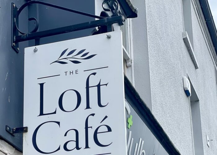 The Loft Cafe sign and hanging flower baskets whsjwx