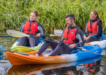 Three people in life vests kayaking on water