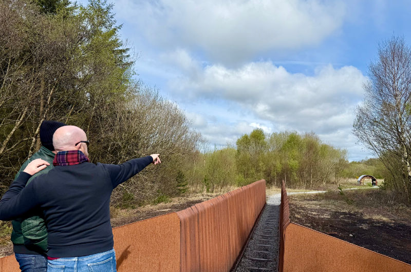 Two Men Pointing At Landscape From Metal Walkway