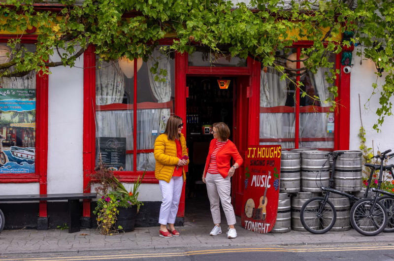 Two women standing outside JJ Houghs Singing Pub it8fpl