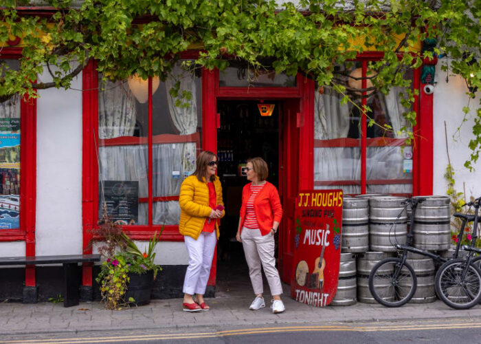 Two women talking outside JJ Houghs Singing Pub czlyhx