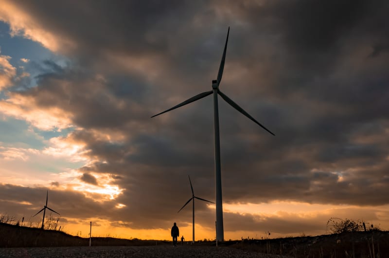 Wind turbines silhouette at sunset with dramatic sky h7afaf