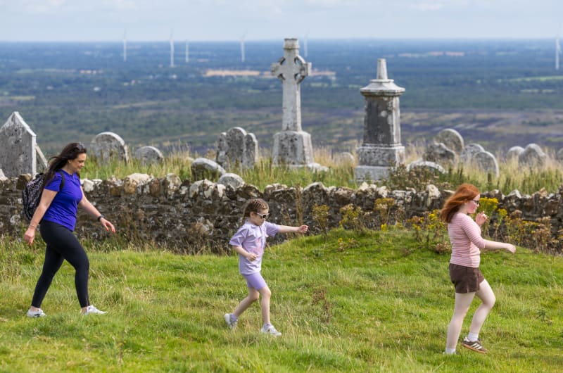 Woman And Children Walking Near An Old Cemetery tmnnti