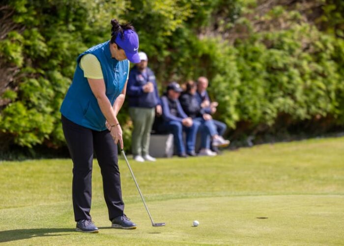 Woman In Blue Vest Putting On Golf Green f5yft0