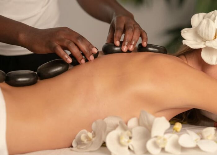 Woman Receiving Hot Stone Massage At Spa plailo
