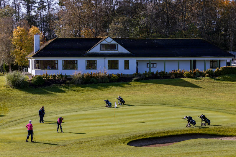 birr golf people playing on green by house