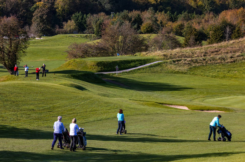 birr golf people with caddys walking to green