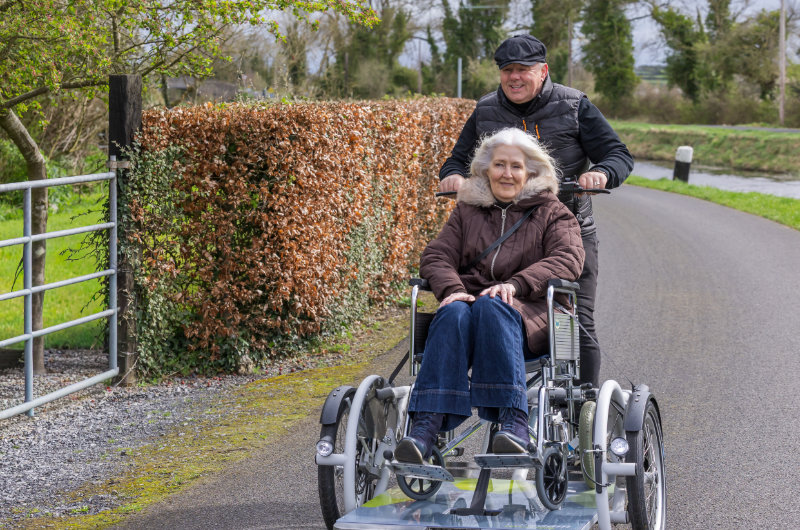 man and woman on wheelchair assisted bike