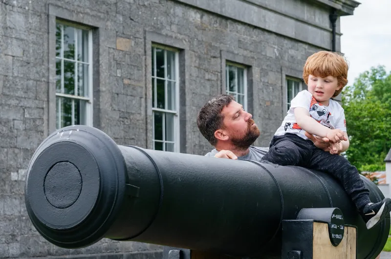 man with child by cannon