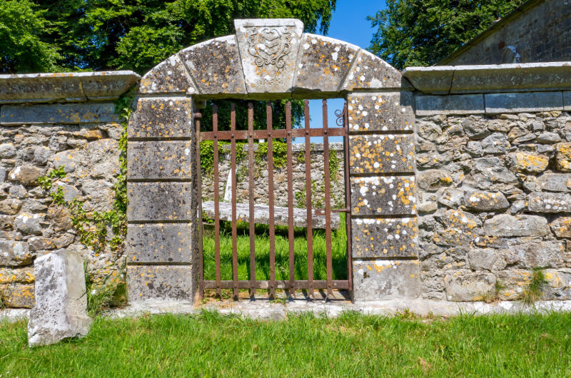 old stone wall with rusty gate