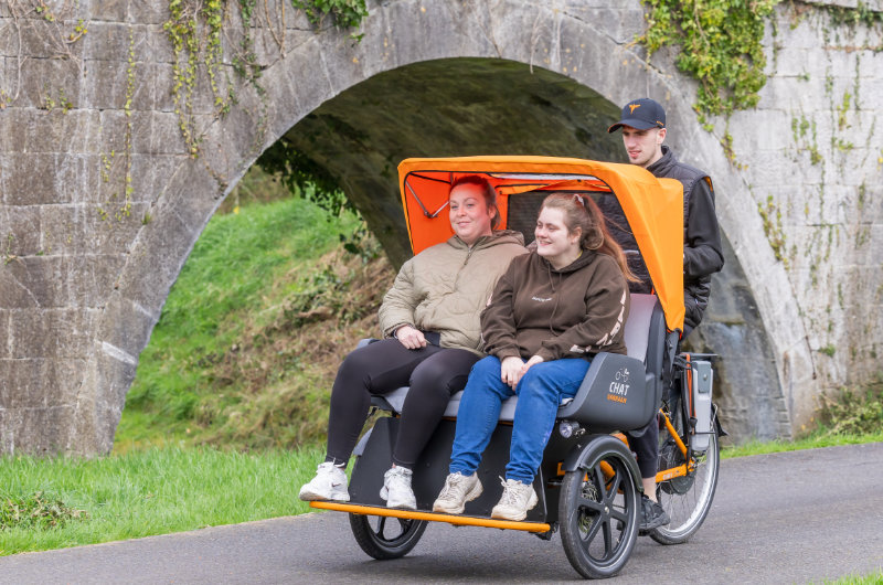 two women on rickshaw passing bridge