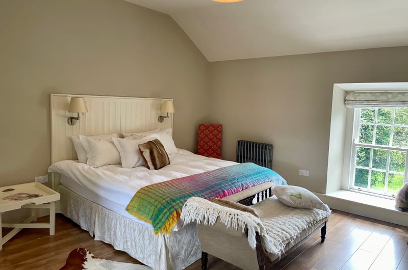 Cozy Bedroom With White Bed And Colorful Throw