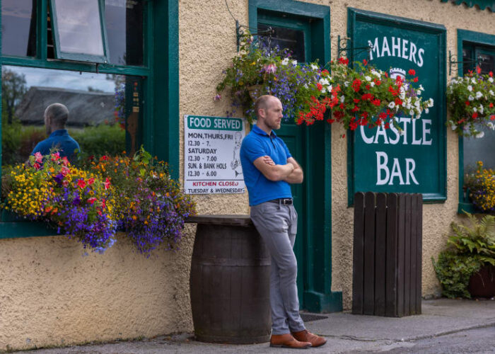 Man Leaning Against Barrel Outside Mahers Castle Bar eevrij