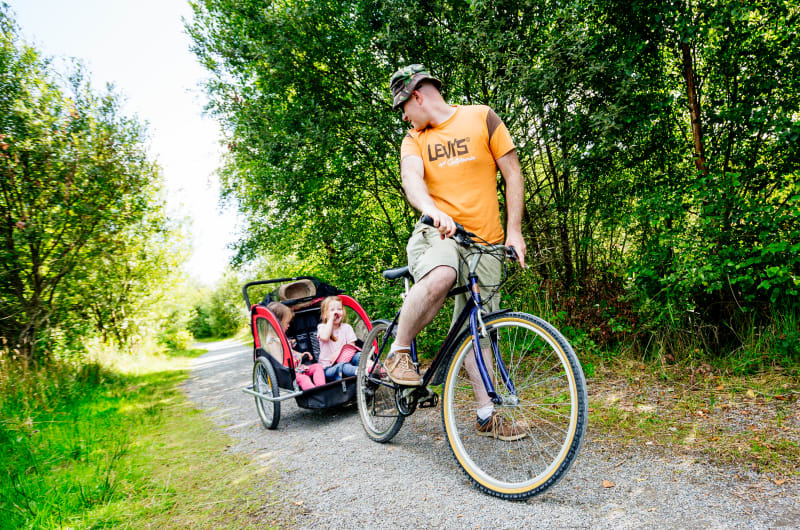 Man cycling with children in bike trailer g4vdhf