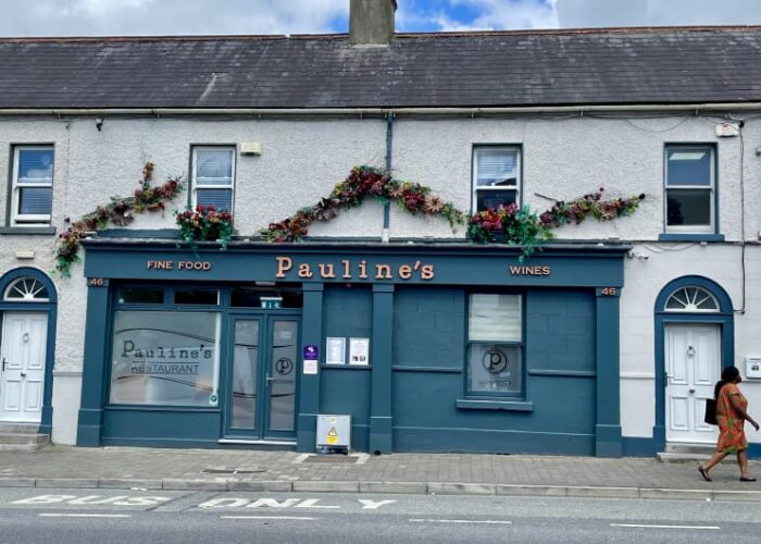 Paulines Restaurant storefront with floral garlands