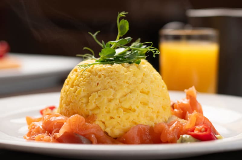 Scrambled eggs and smoked salmon with orange juice