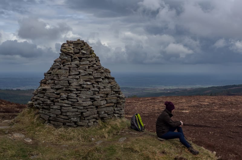 Stone Cairn And Hiker On Scenic Cloudy Hilltop baa7o5