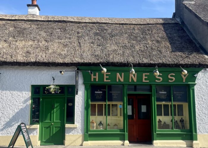 Traditional Hennessy Pub With Thatched Roof Green Storefront