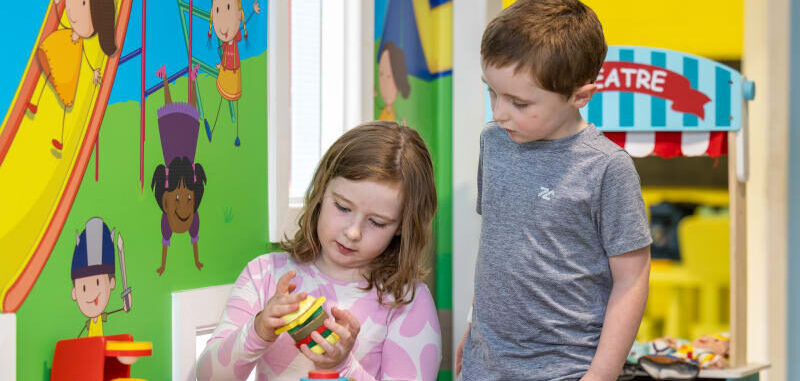 Two Children Playing With A Toy Tea Set aymfkg