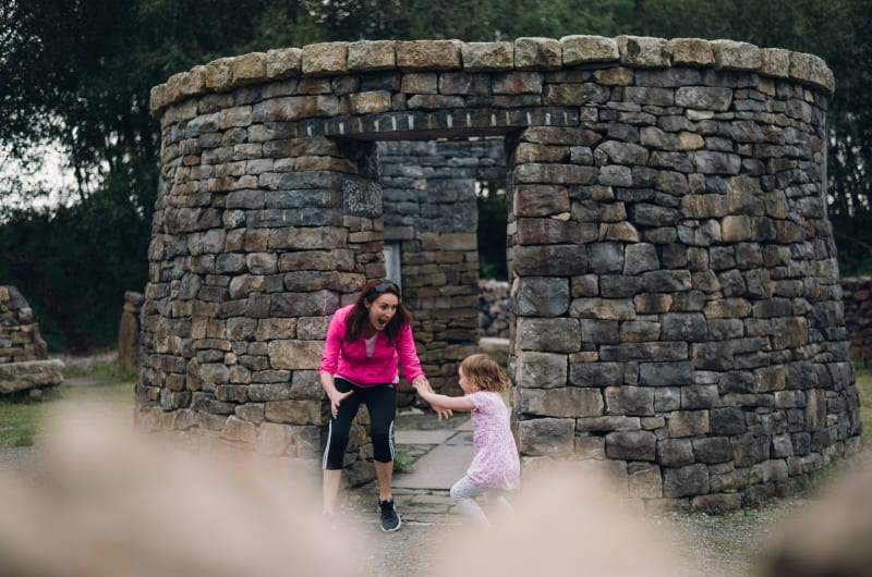 Woman and girl playing by stone structure boy4xi