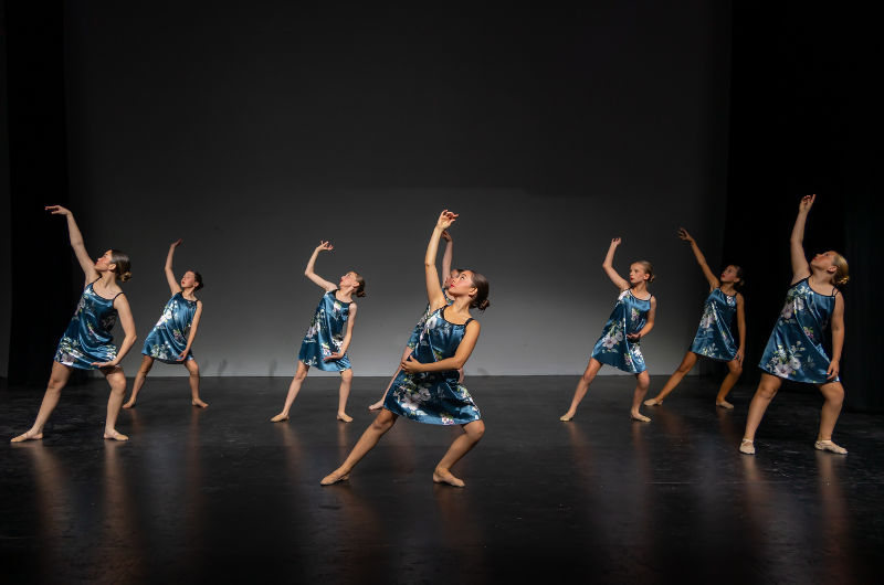 group of girls in blue dresses dancing on stage