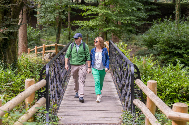 man and woman walking across foot bridge