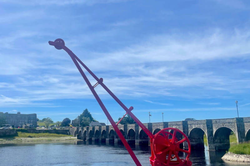 red crane by river bridge