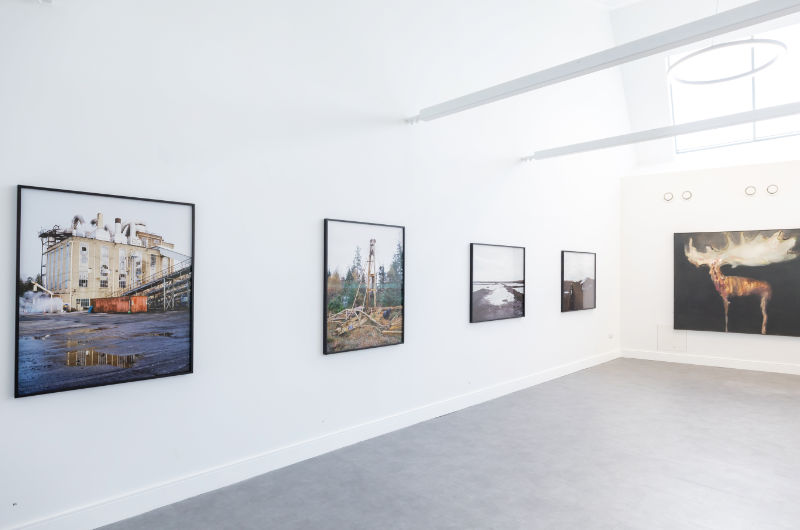 white gallery walls with hung paintings grey floor