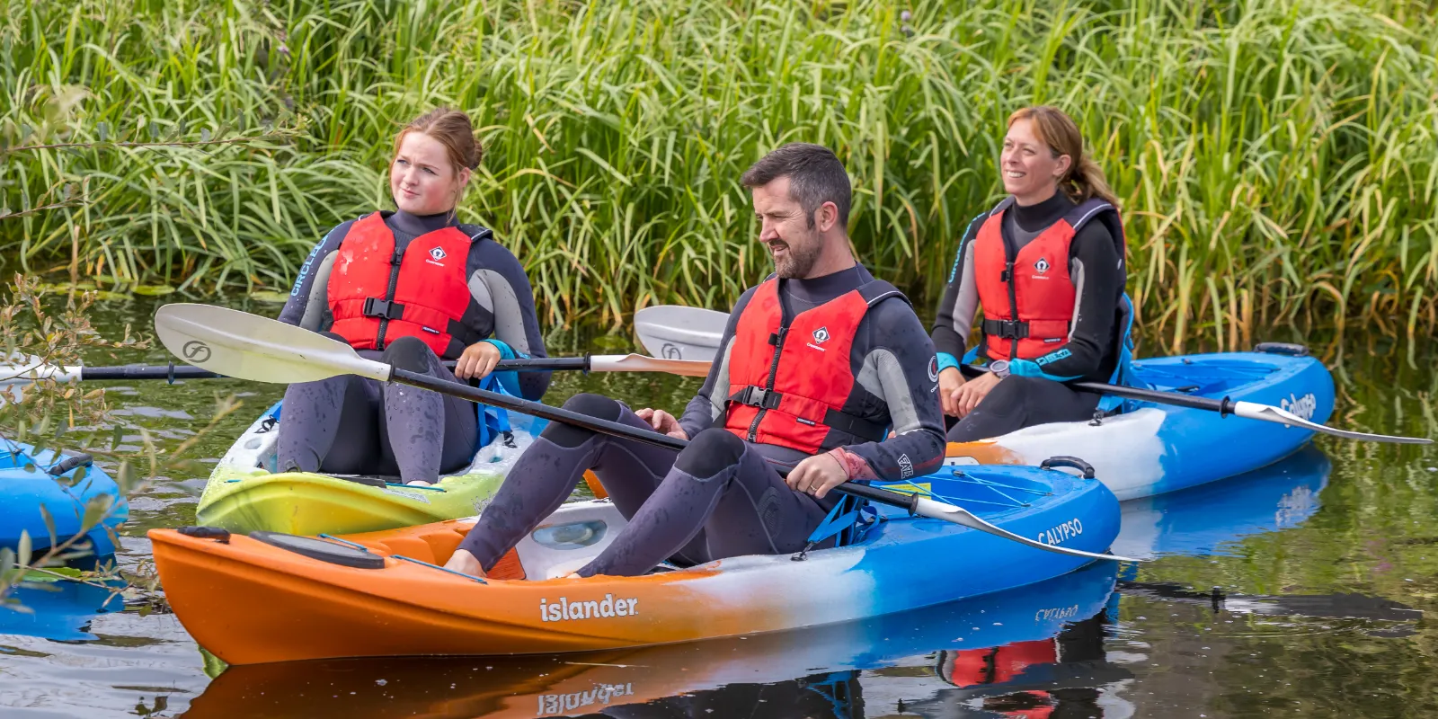 header watersports three people in canoes on river