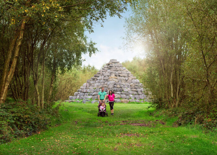 hero young family walking through trees stone pyramid in background
