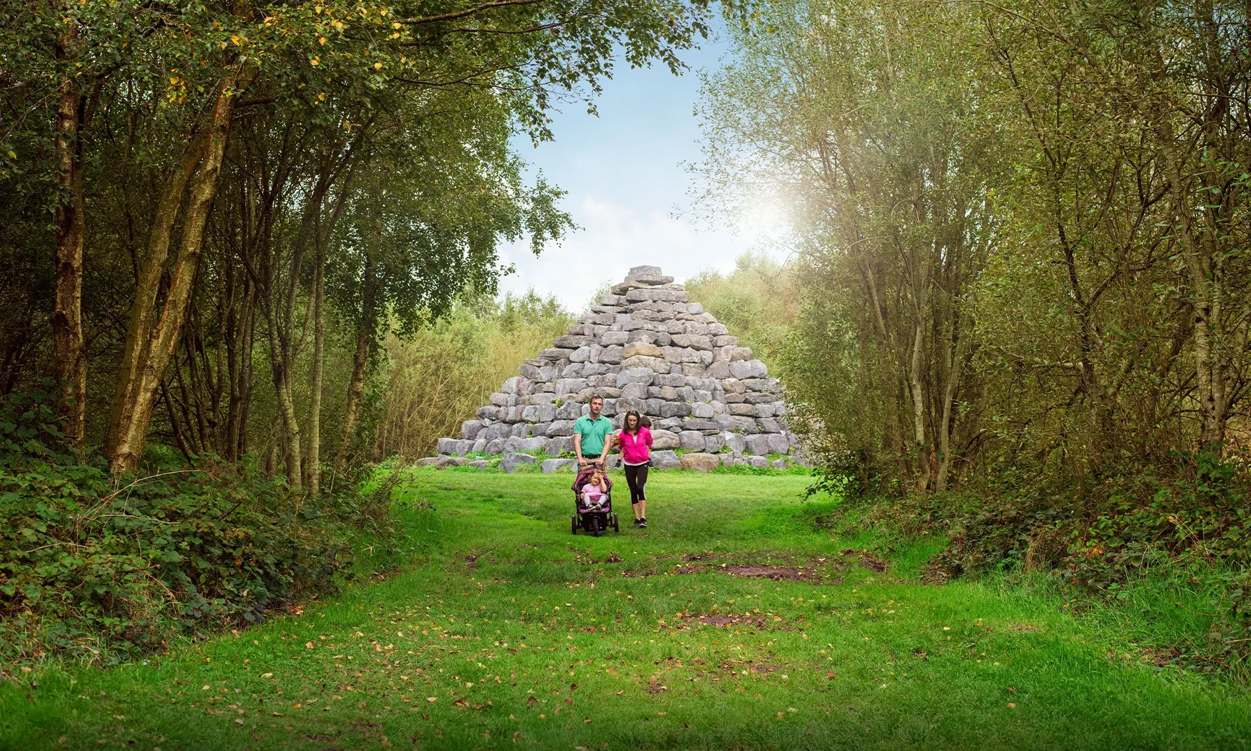 hero young family walking through trees stone pyramid in background