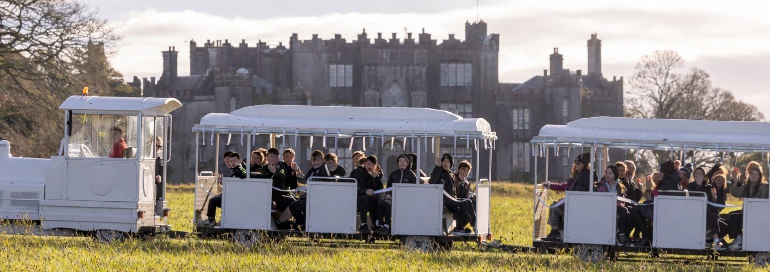 White tourist train by the castle e1770224723379